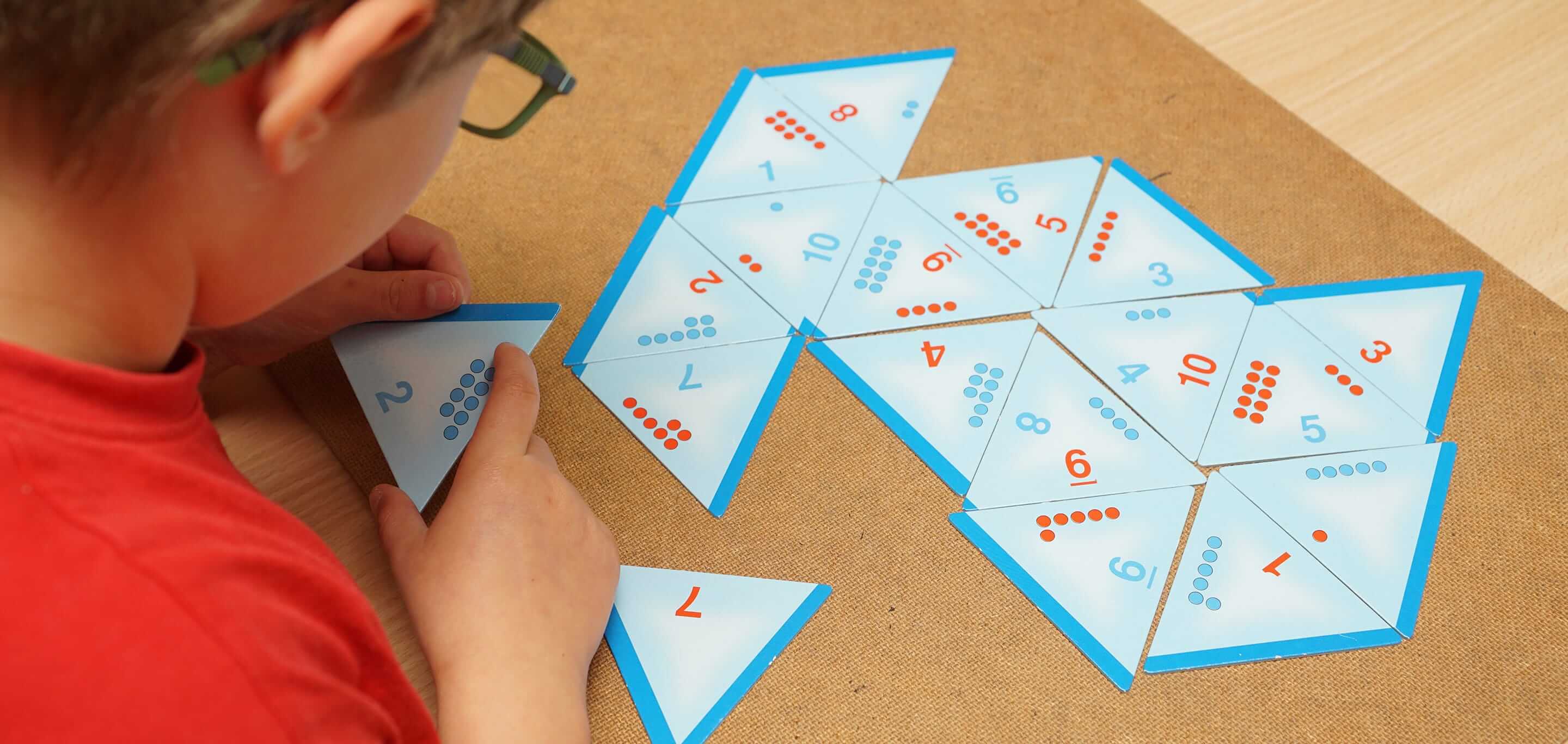 Kind ordnet Karten mit Zahlen auf den Tisch